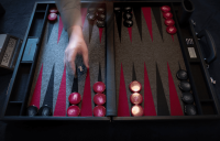 A backgammon set including a board, two sets of 15 pieces, two pairs of dice and a doubling cube.